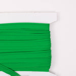 Bright green cotton piping trim wound on a white cardboard spool, 1 yard