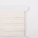 White cotton piping trim wound on a cardboard spool, solid rice color