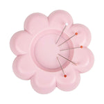Pink flower-shaped magnetic pin holder with sewing pins, daisy petal design