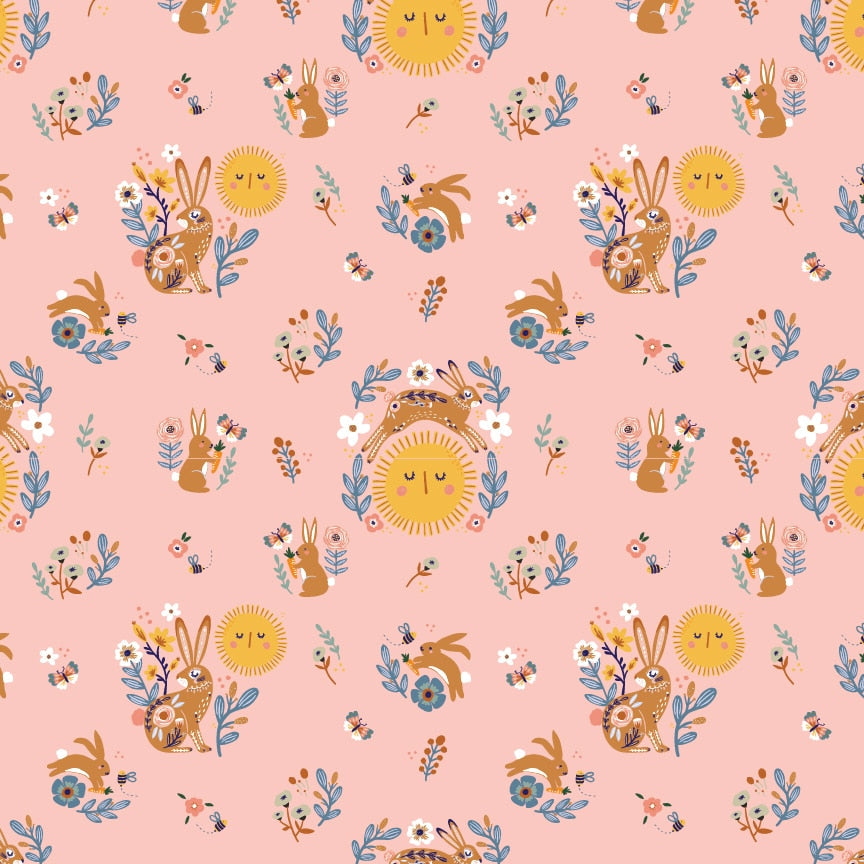 Pink fabric with golden suns, brown bunnies, blue florals, and bees in a folk art pattern.