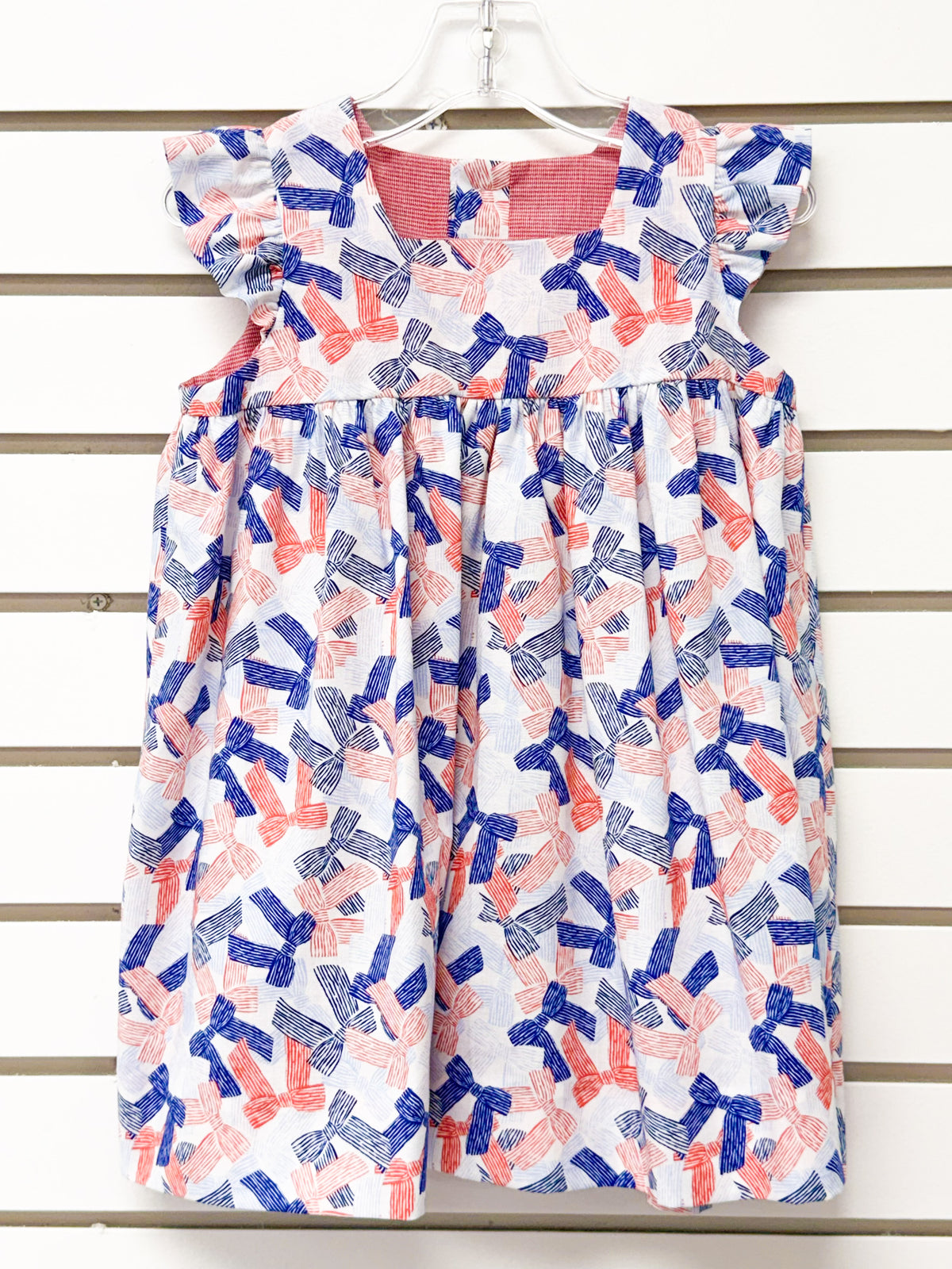 Girl's white dress with red and blue bow print, flutter sleeves, size 24mo