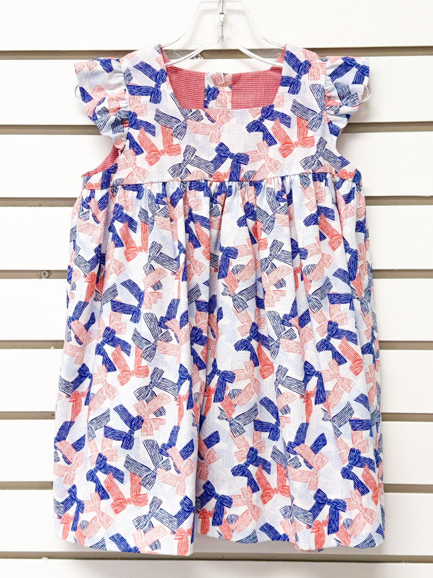 Girl's white dress with red and blue bow print, flutter sleeves, size 24mo
