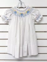 White smocked bishop dress with blue and yellow embroidery, puff sleeves, lace trim