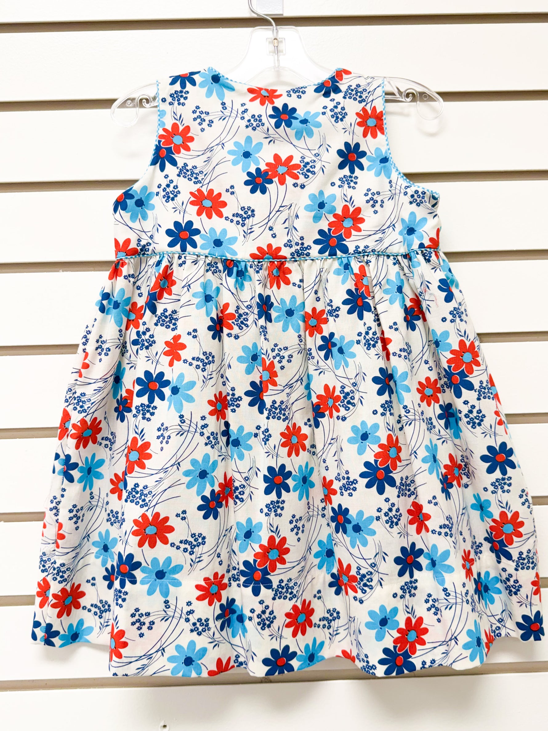 Girl's white sleeveless dress with red, navy, and light blue daisy floral print