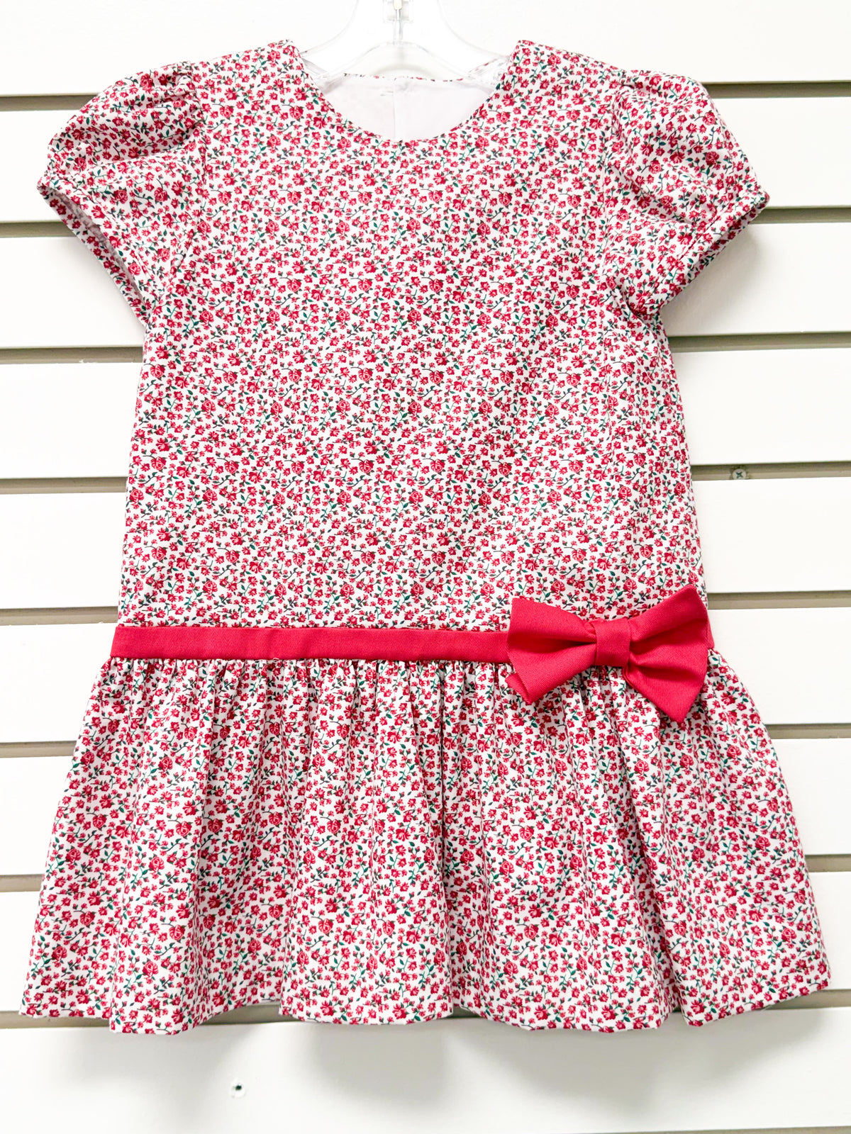 Girl's white drop-waist dress with red floral print, short sleeves, and red bow belt