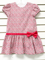 Girl's white drop-waist dress with red floral print, short sleeves, and red bow belt