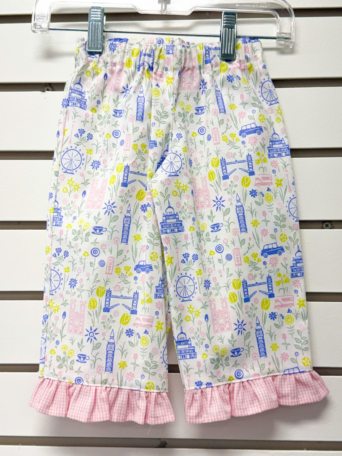White children's pants with London landmarks print and pink gingham ruffle hem
