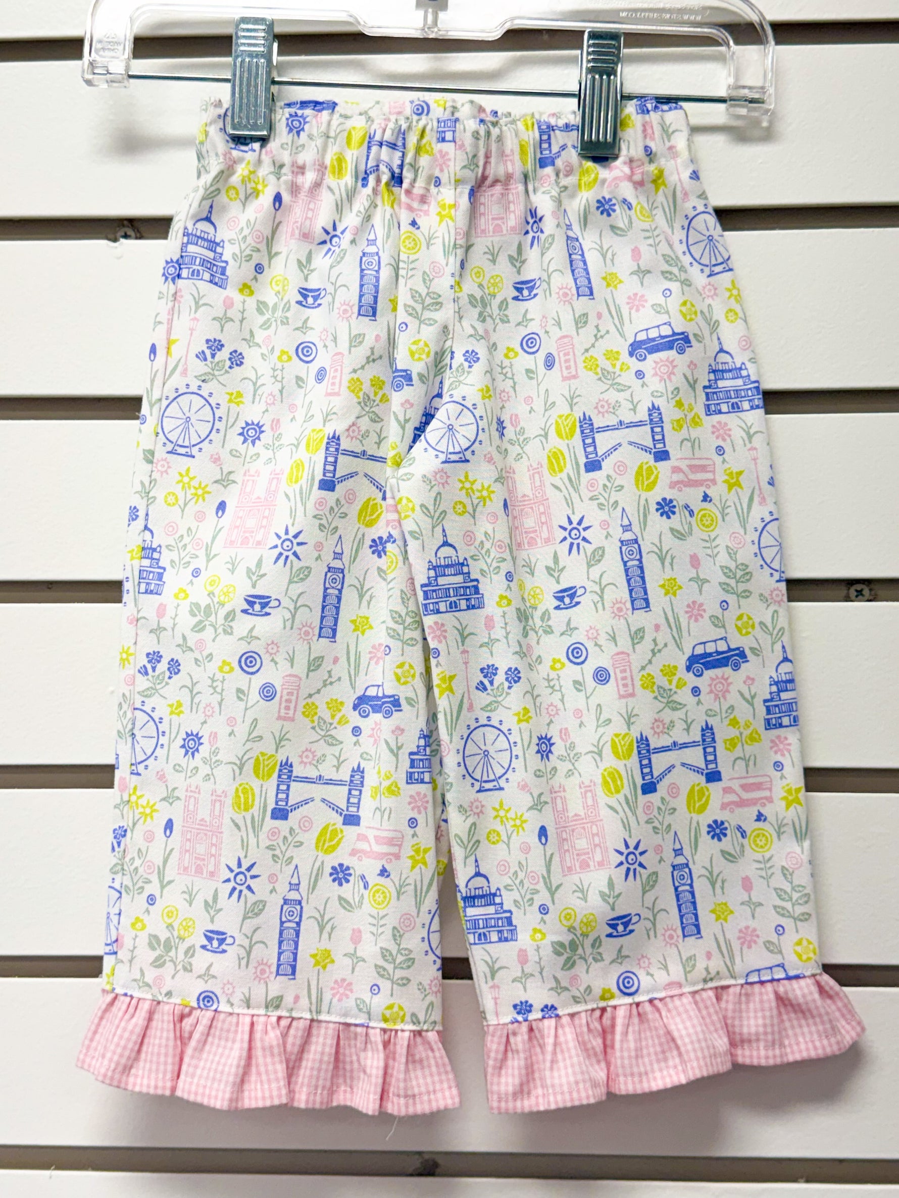 White children's pants with London landmarks print and pink gingham ruffle hem