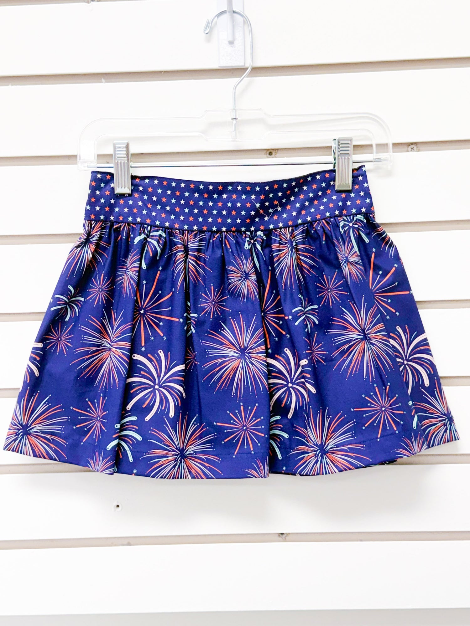 Navy blue gathered skirt with fireworks print and star-patterned waistband, size 4