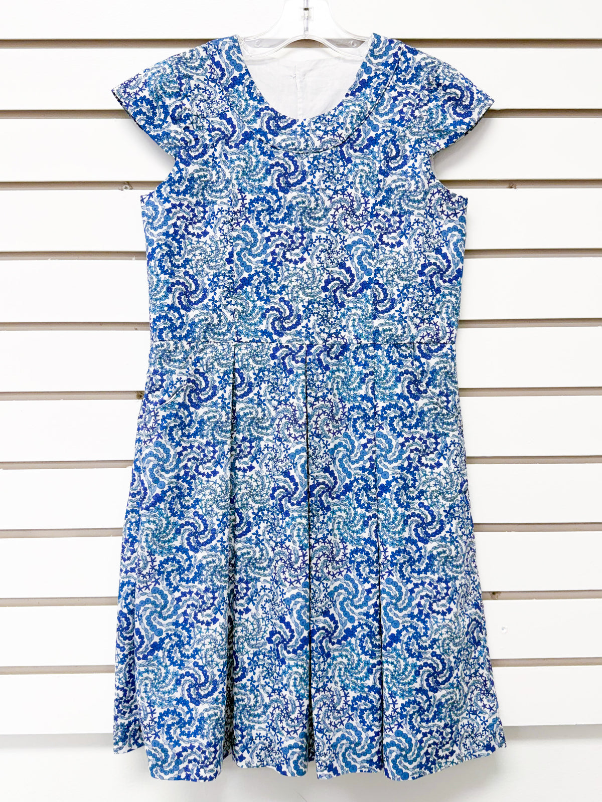 Girl's blue and white swirl print sleeveless dress with pleated skirt, size 8