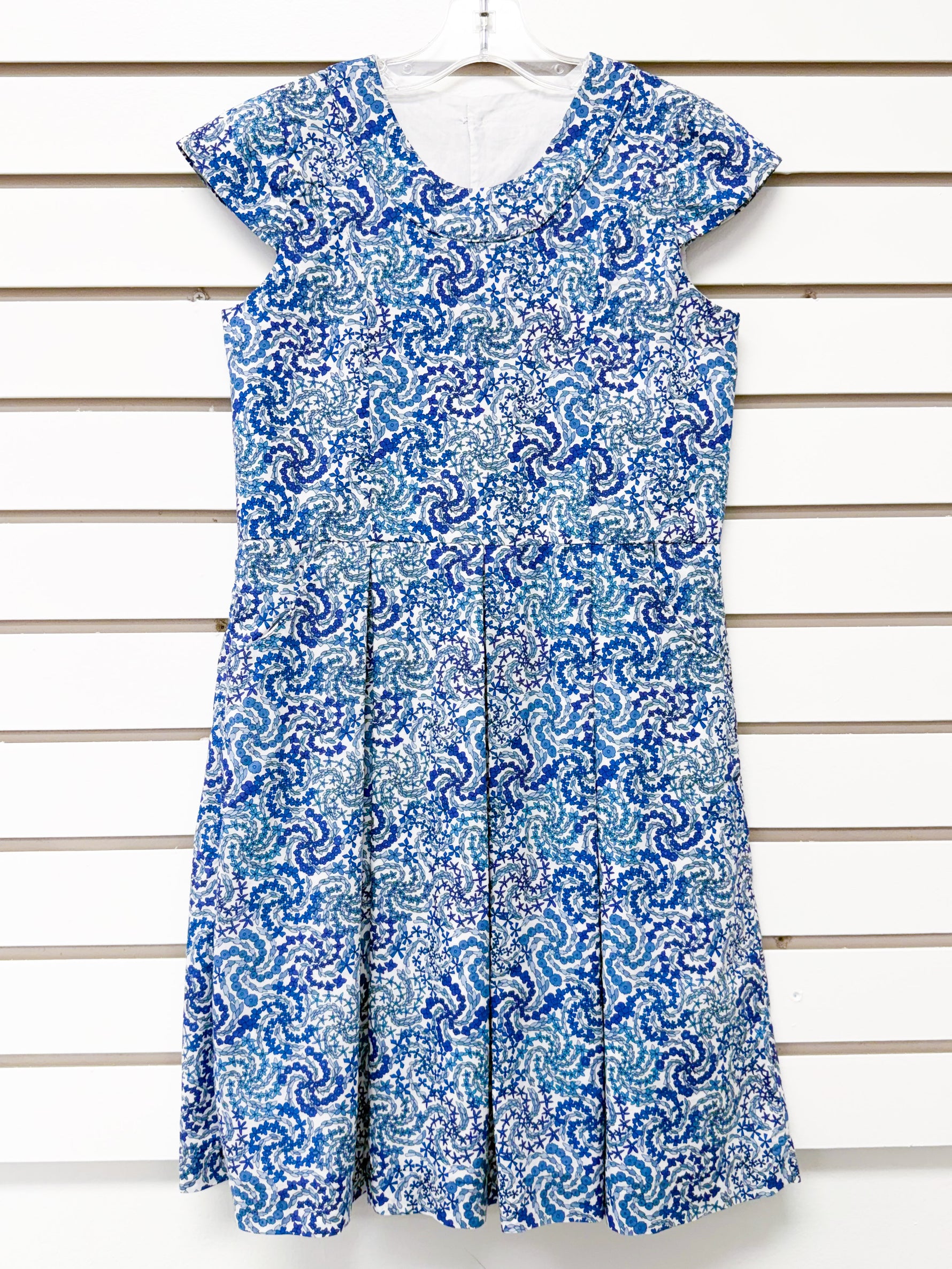 Girl's blue and white swirl print sleeveless dress with pleated skirt, size 8