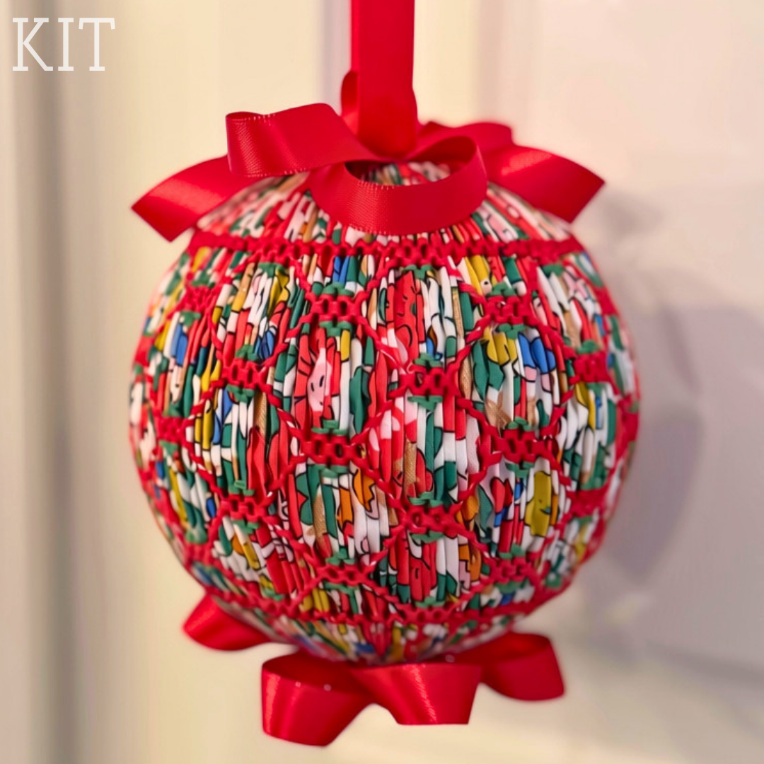 Smocked Christmas ornament ball in colorful Liberty fabric with red ribbon bows