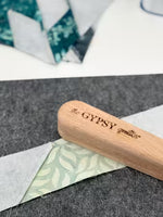 The Gypsy Quilter small wooden clapper tool pressing fabric seams on felt mat
