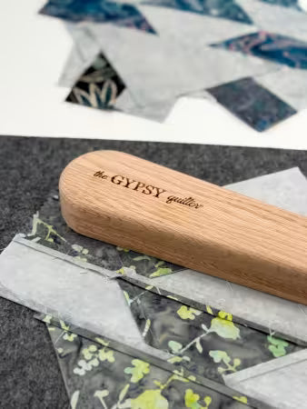 The Gypsy Quilter large wooden clapper pressing tool on quilting fabric