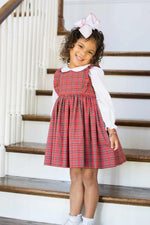 Red and green tartan plaid fabric made into a classic girls pinafore dress