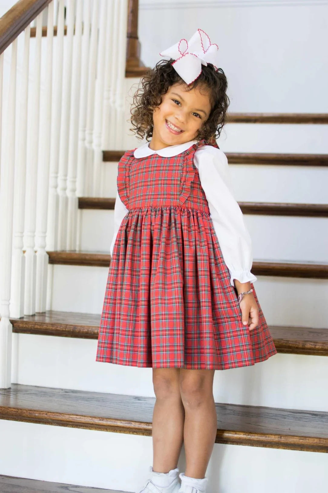 Red and green tartan plaid fabric made into a classic girls pinafore dress