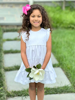 Girl in white tiered ruffle dress holding magnolia flower, Pima White fabric