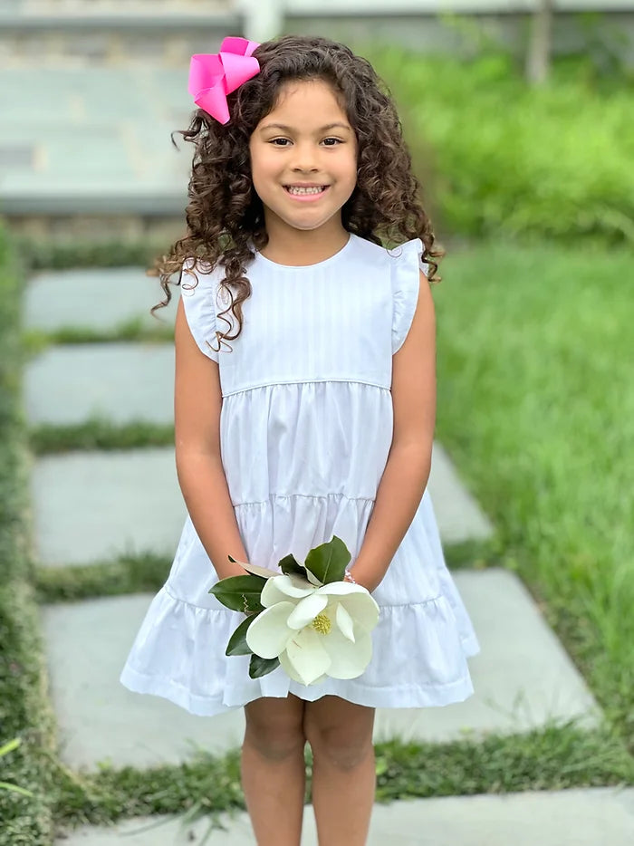 Girl in white tiered ruffle dress holding magnolia flower, Pima White fabric