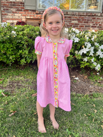 Girl wearing pink gingham dress with floral trim, Peter Pan collar, and puff sleeves
