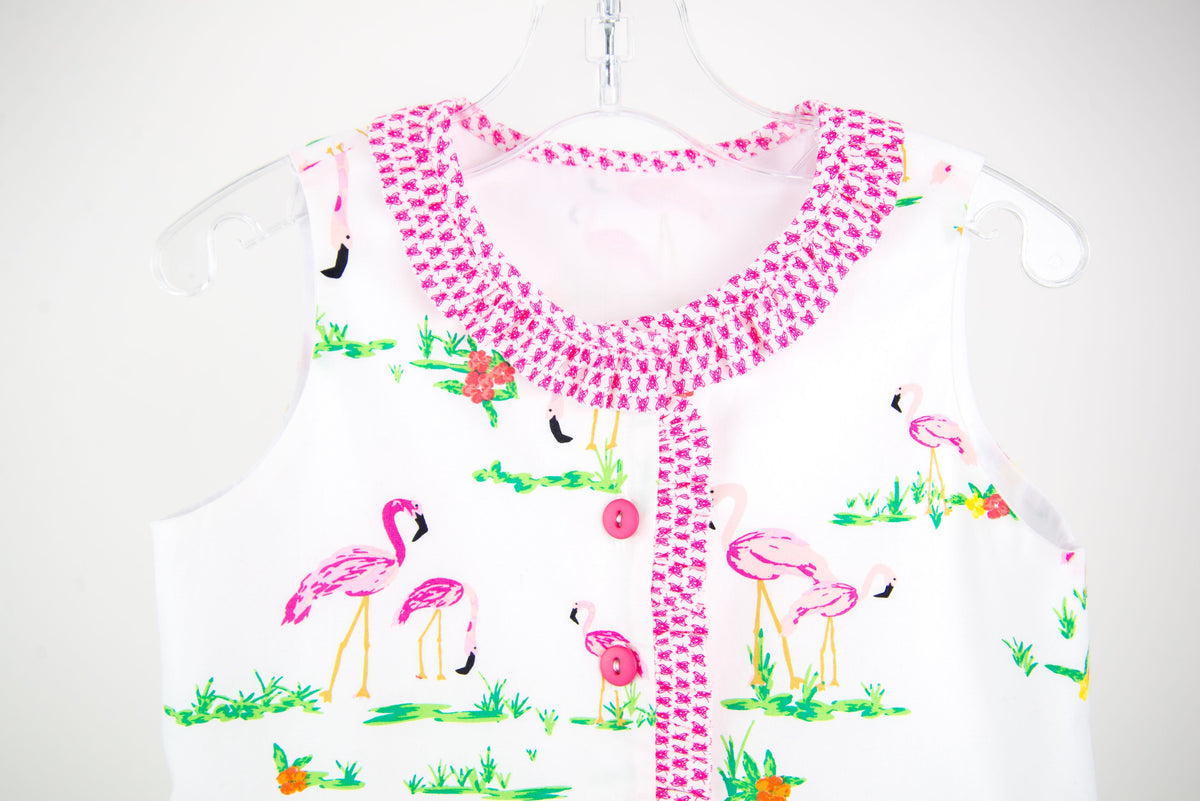 White fabric with pink flamingo print, shown as a finished child's sleeveless top