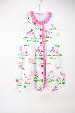 White children's dress with pink flamingo print and pink button front closure
