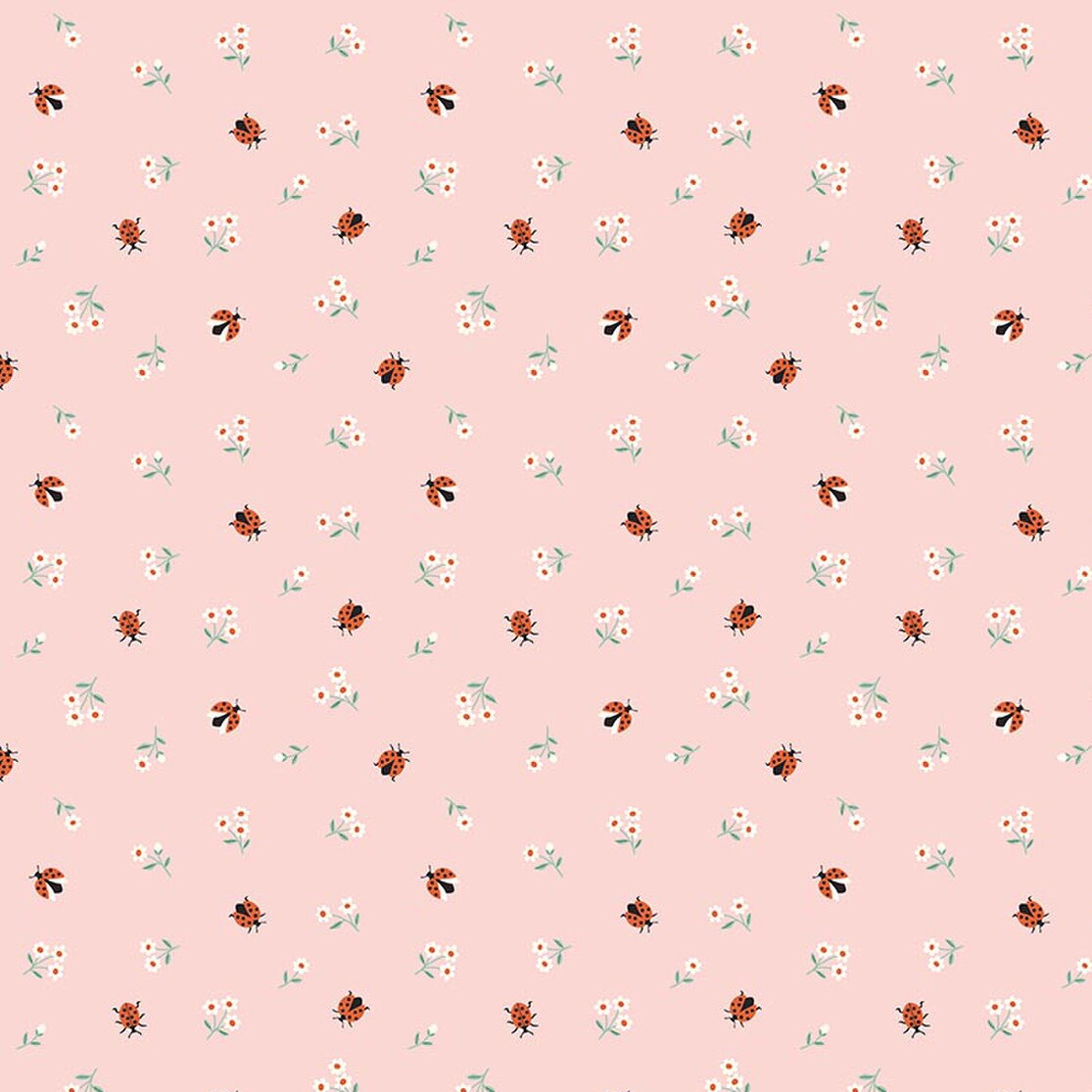 Pink quilting fabric with scattered red ladybugs and tiny white daisy flowers