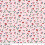 Pink cotton fabric with scattered ditsy floral print in red, pink, and blue