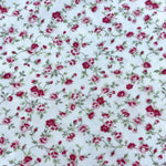 White cotton fabric with crimson and pink rose floral print and green vines