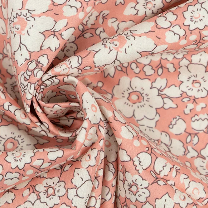 Pink poplin fabric with white daisy floral print, draped and twisted to show texture