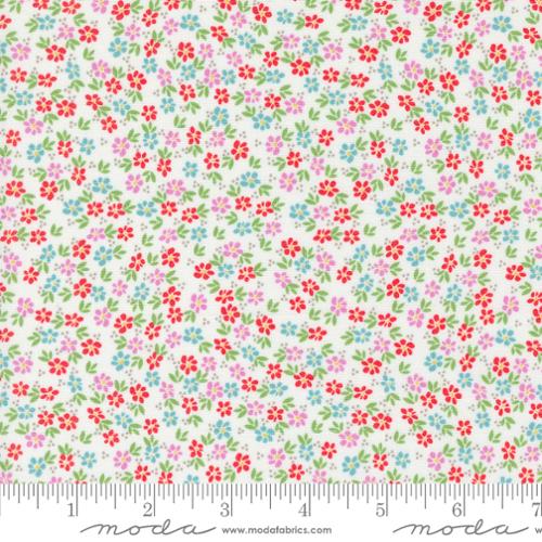 White quilting fabric with scattered red, pink, and blue floral ditsy print