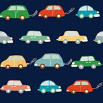 Navy blue knit fabric with colorful cartoon cars in red, green, yellow, and teal