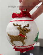 Smocked white Christmas ornament ball with embroidered reindeer, red ribbon bow and trim