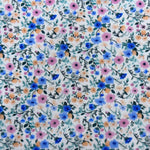 White cotton fabric with small blue, pink, and orange floral ditsy print pattern