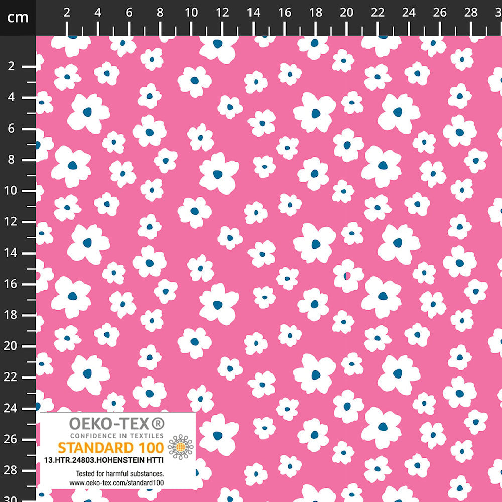 Pink knit fabric with white daisy blossoms and blue centers, shown with ruler