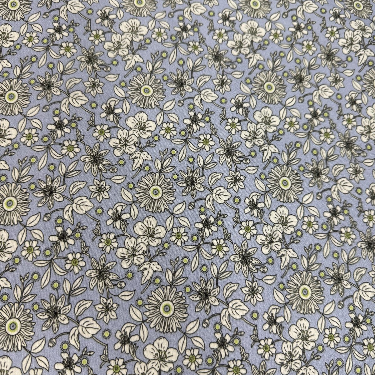 Periwinkle blue fabric with cream floral sketch print and green accent centers
