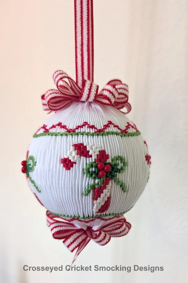 White smocked Christmas ornament with candy cane, holly, red ribbon bow embroidery details