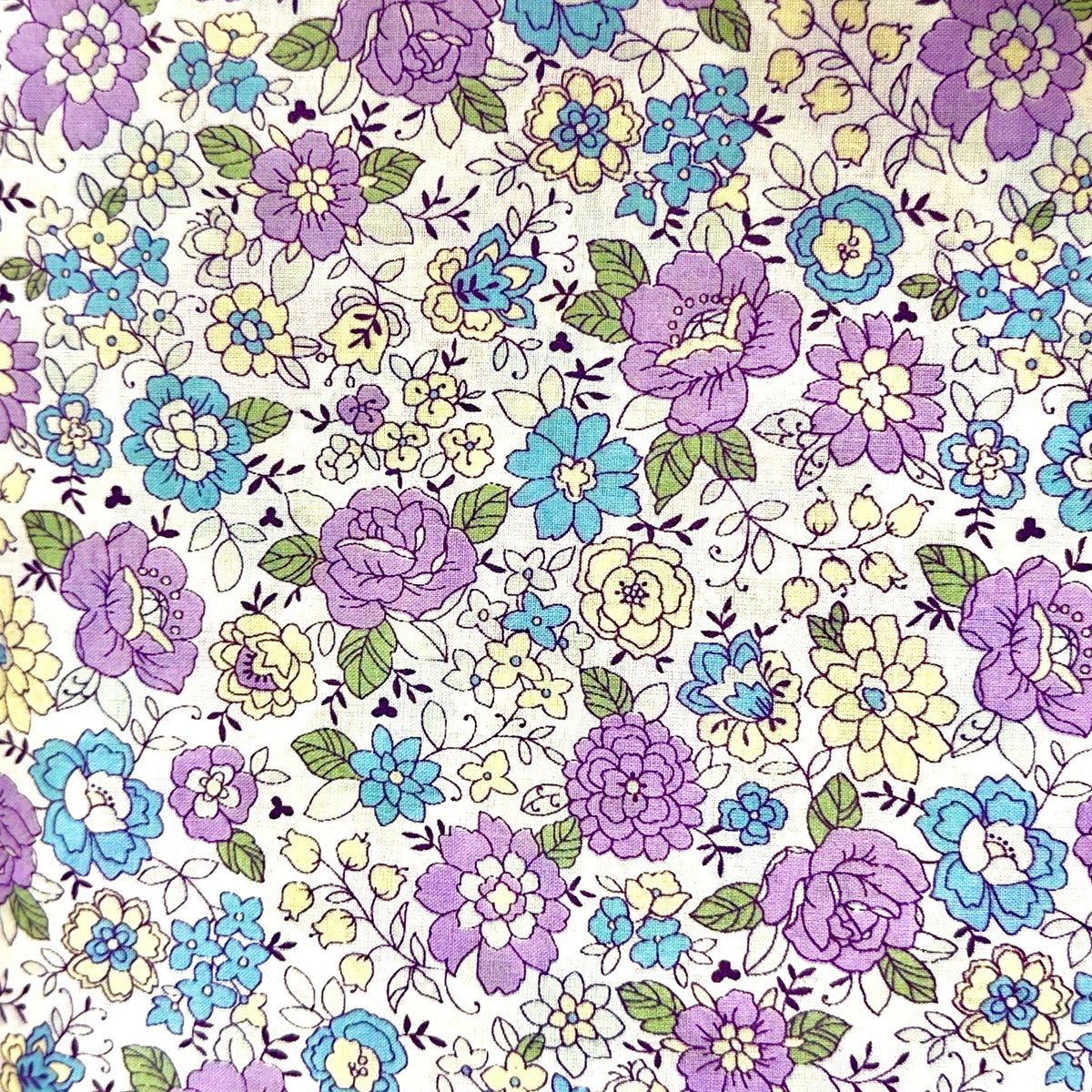 Yuwa lawn fabric with purple, blue, and yellow floral print on white background