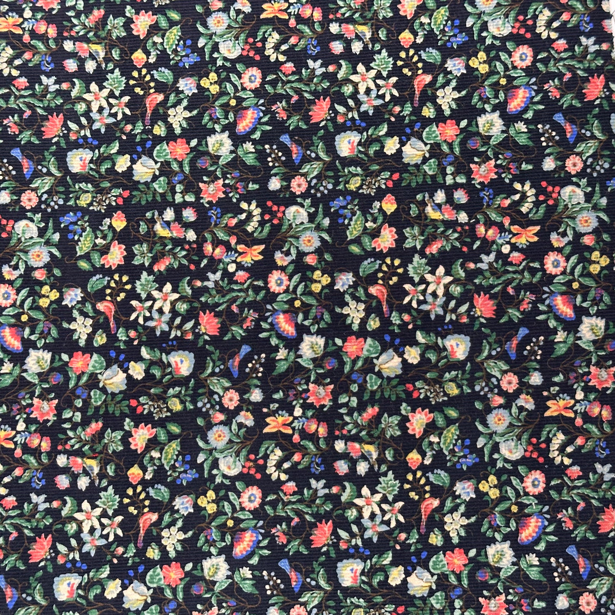 Navy blue corduroy fabric with dense multicolor floral and paisley print pattern