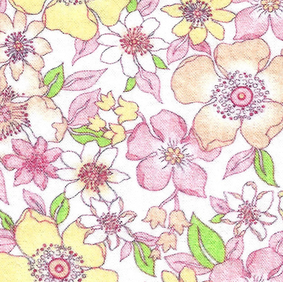 Seersucker fabric with pink, yellow, and white floral print on white background with green leaves