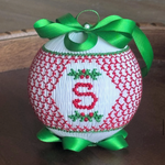 White smocked Christmas ornament with red embroidered letter S and green satin bow