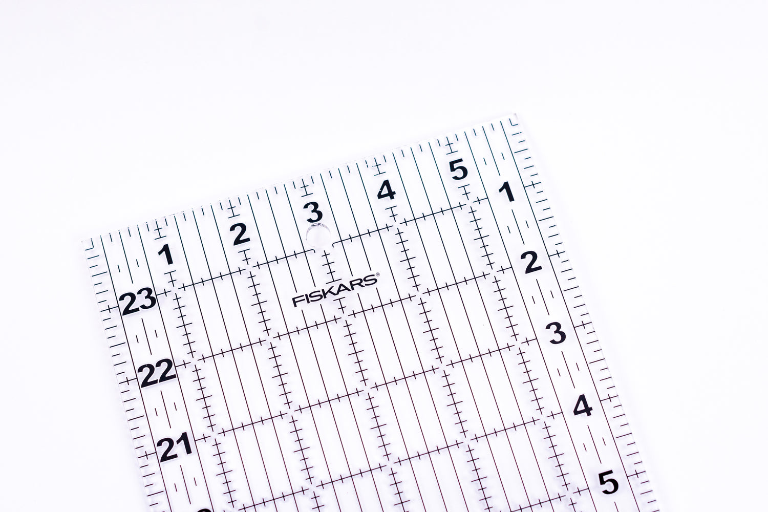 Fiskars clear acrylic quilting ruler with black grid lines and inch markings
