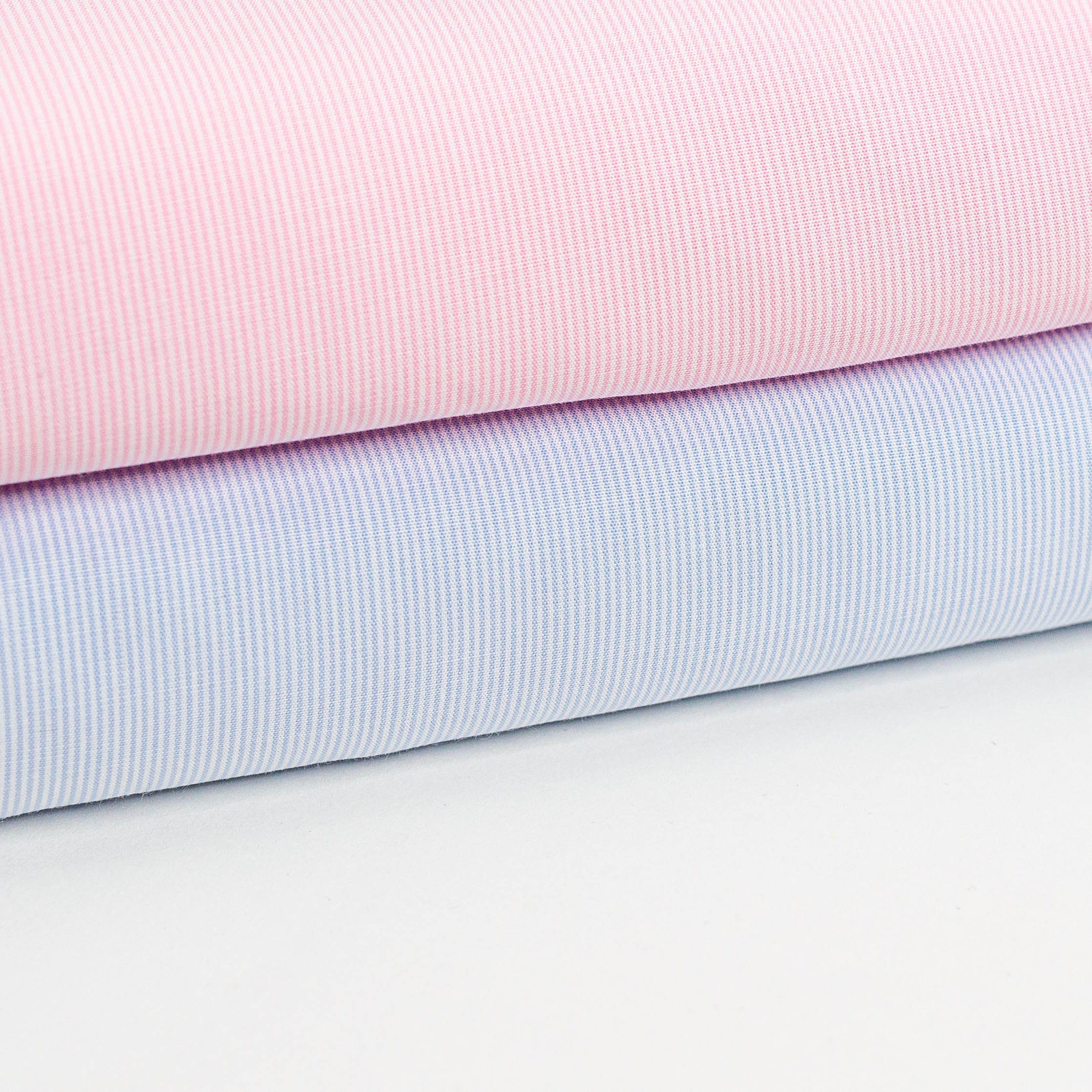 Folded pink and blue baby stripe cotton fabric bolts stacked together