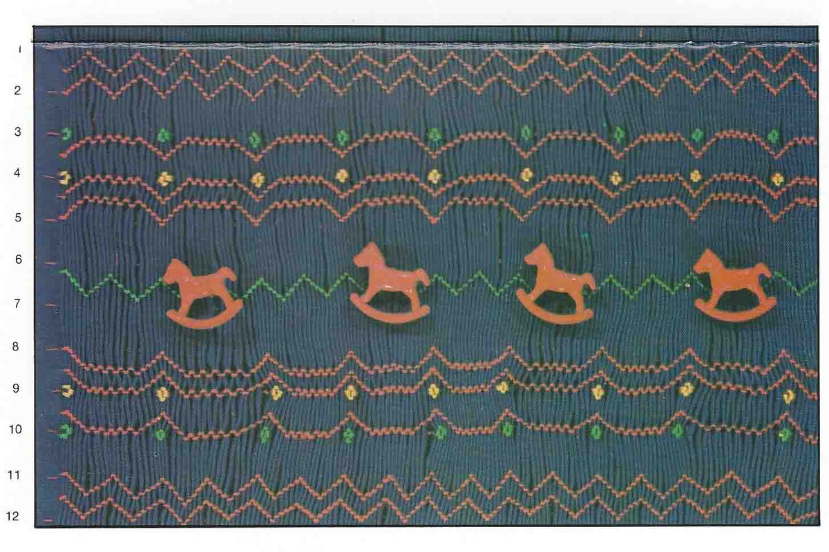 Fantasy smocking plate with rocking horse buttons, zigzag stitches in orange and green on navy fabric.