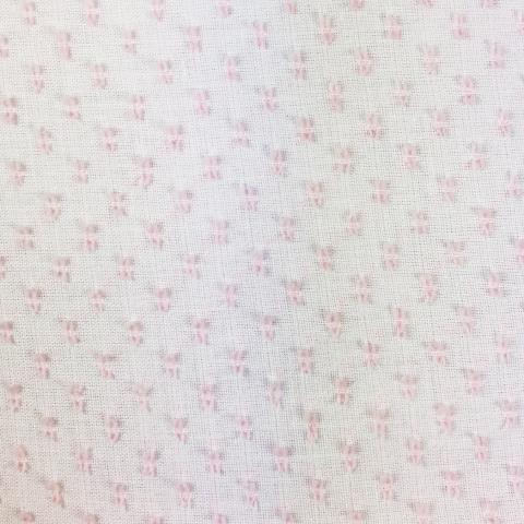 White sheer poly dotted swiss fabric with small pink woven dot pattern throughout