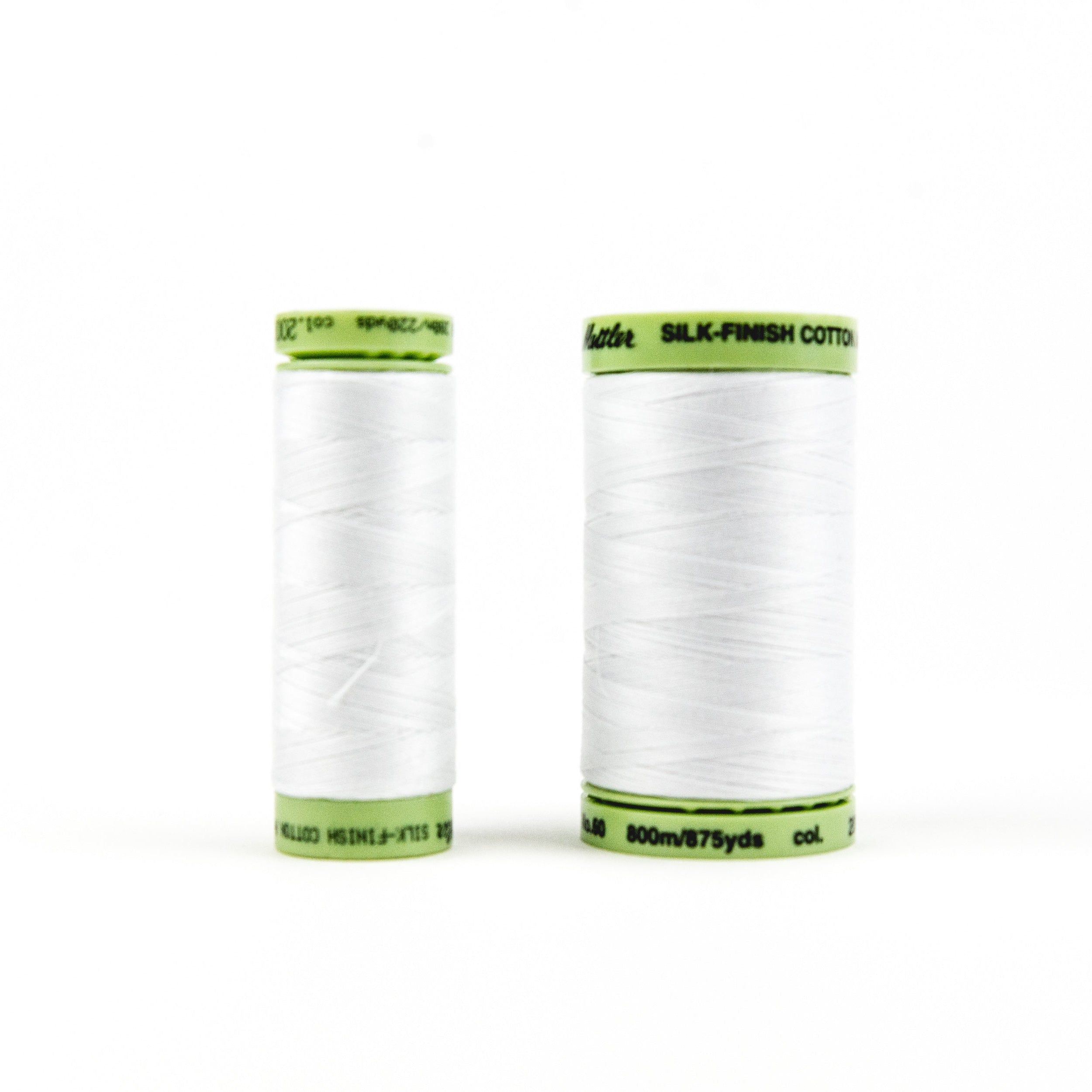Two spools of Mettler Silk-Finish Cotton white thread, small and large sizes