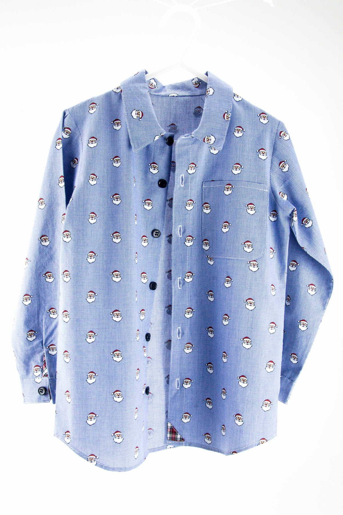 Blue micro check fabric shirt with repeating Santa Claus face pattern and dark buttons